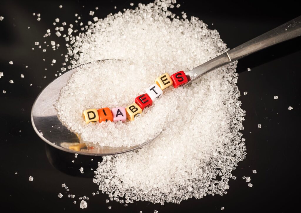 diabetes-written-on-beads-on-a-spoon-with-sugar-underneath-it
