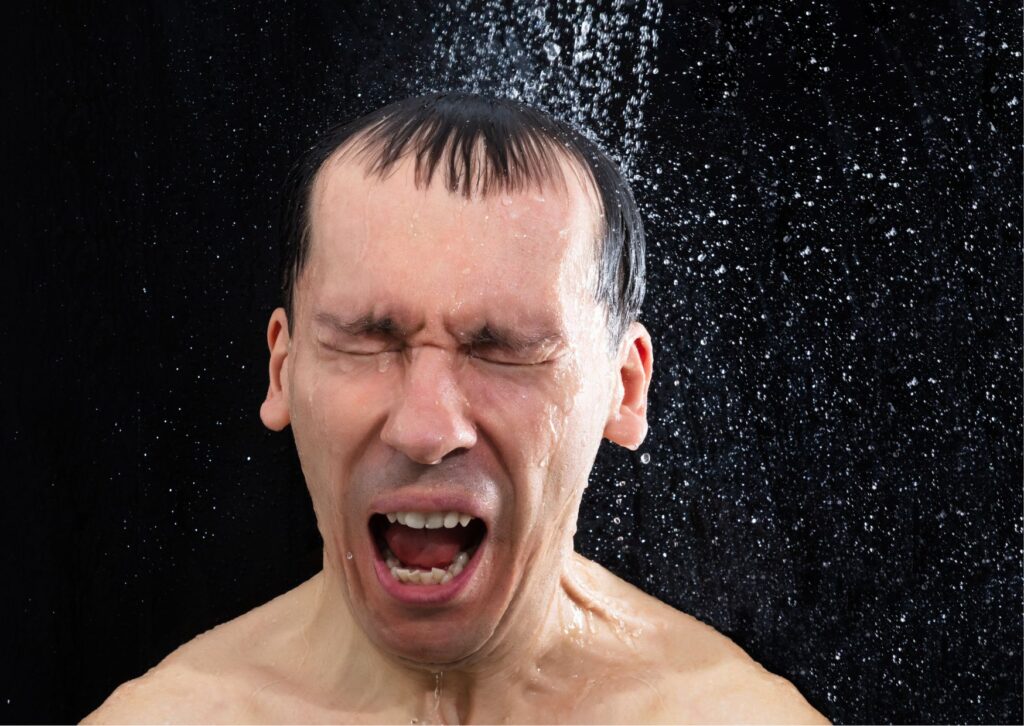 man unhappy in a cold shower