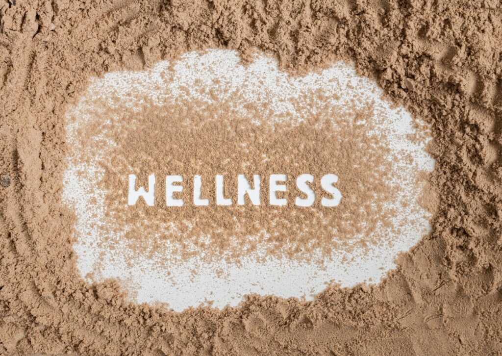 wellness written in the sand