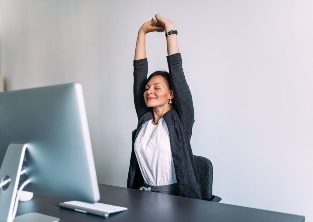 Lady stretching her arms while working from home