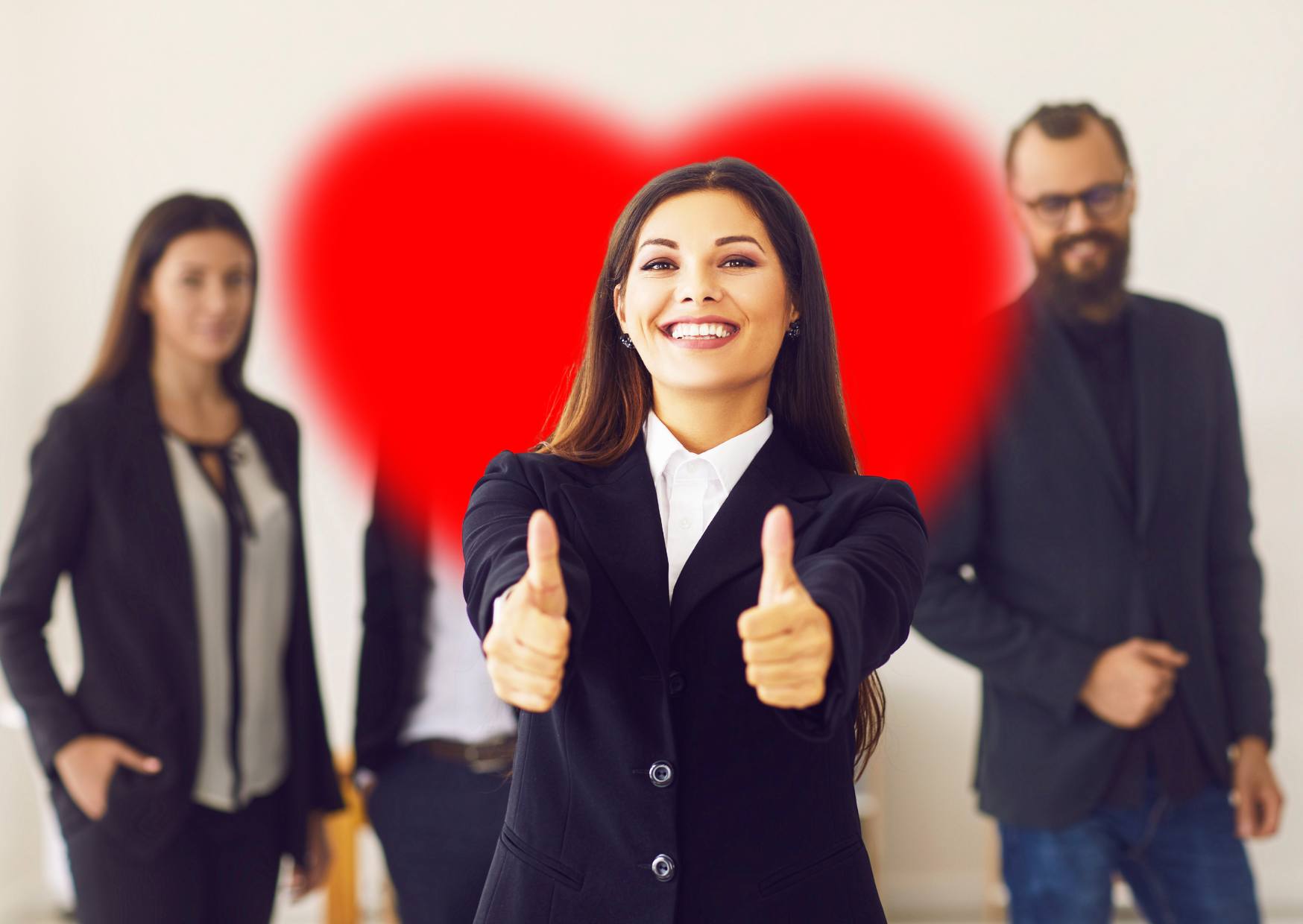 happy-lady-at-work-with-her-thumbs-up-and-a-heart-shape-behind-her-and-male-and-female-work-colleague