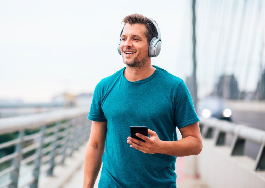 man-walking-with-headphones-and-phone
