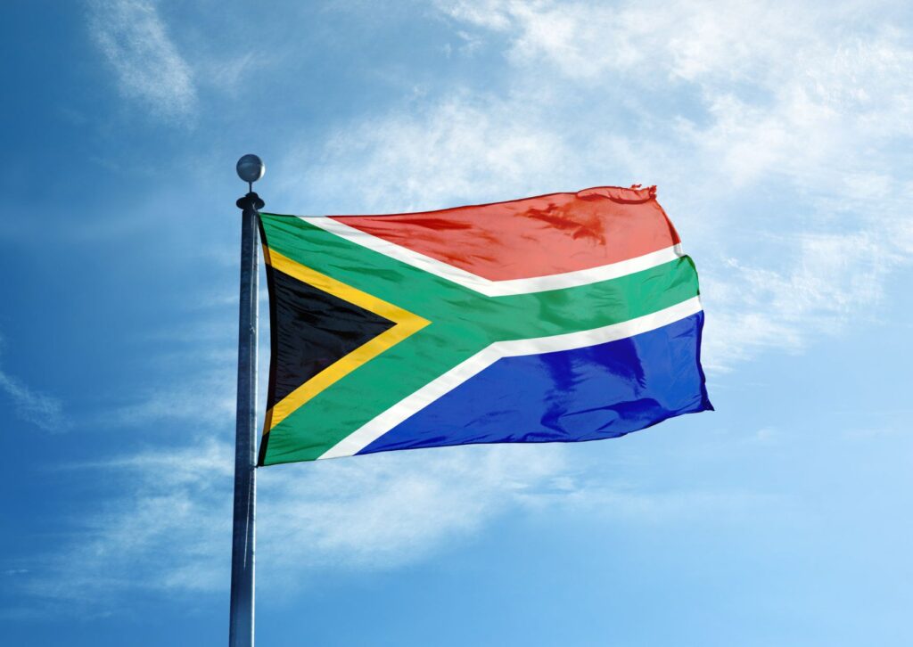 south-africa-flag-infront-of-a-blue-sky-and-light-clouds