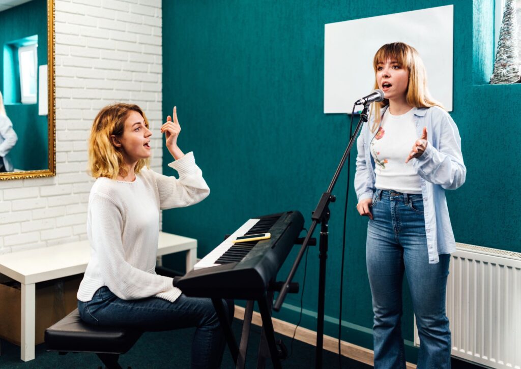 lady-teaching-another-lady-to-sing-in-a-music-lesson