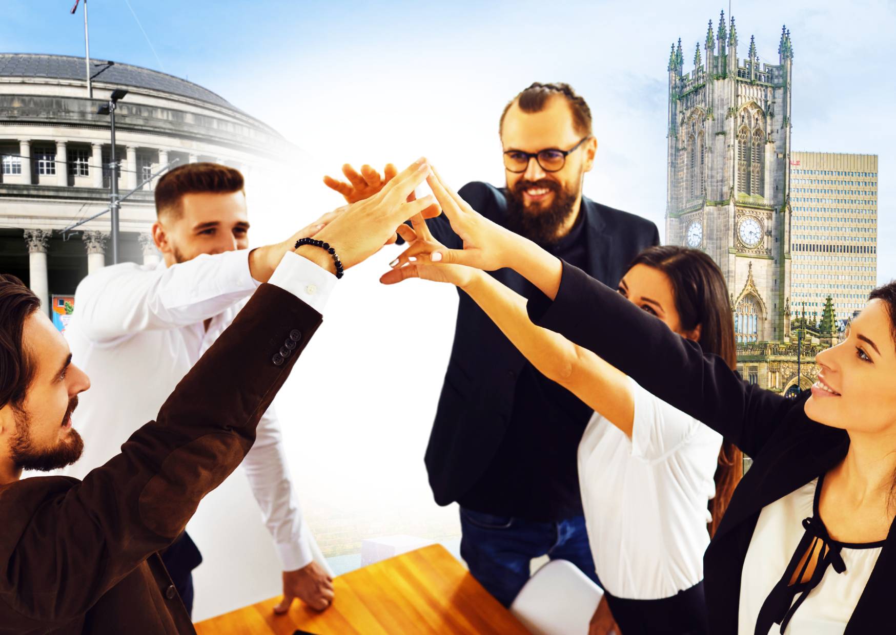 employees-with-hands-up-high-together-emphasising-team-building-with-famous-manchester-landmarks-in-the-background