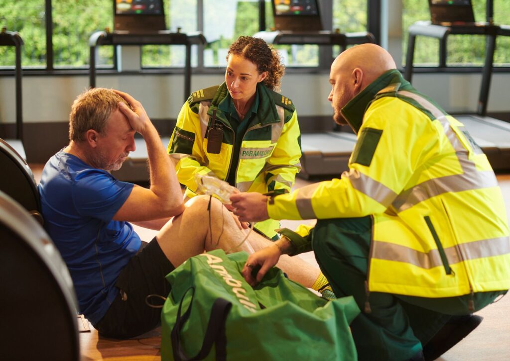 paramedics-looking-after-a-man-who-has-his-hand-on-his-head