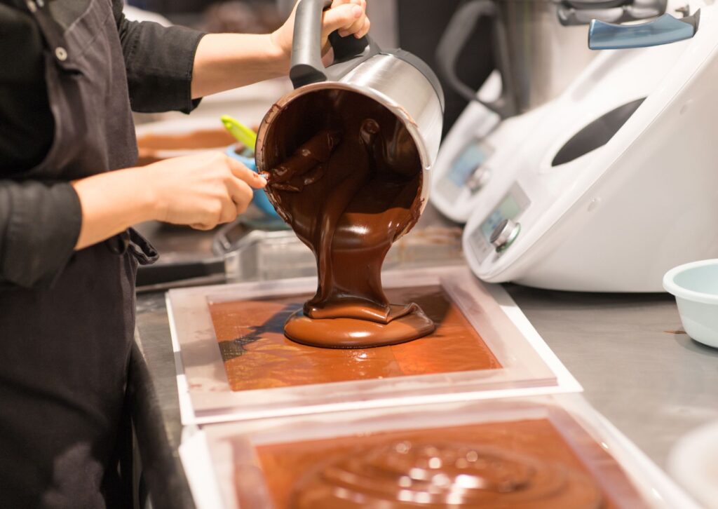 melted-chocolate-being-poured-onto-a-plastic-tray