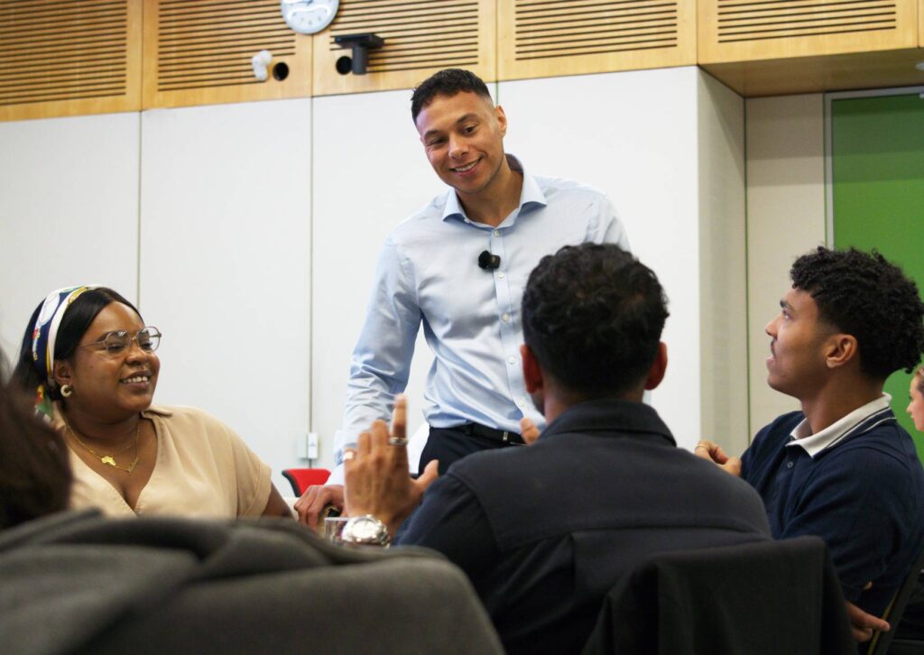 corporate workshop facilitator smiling at employees during a corporate workshop while talking about the session