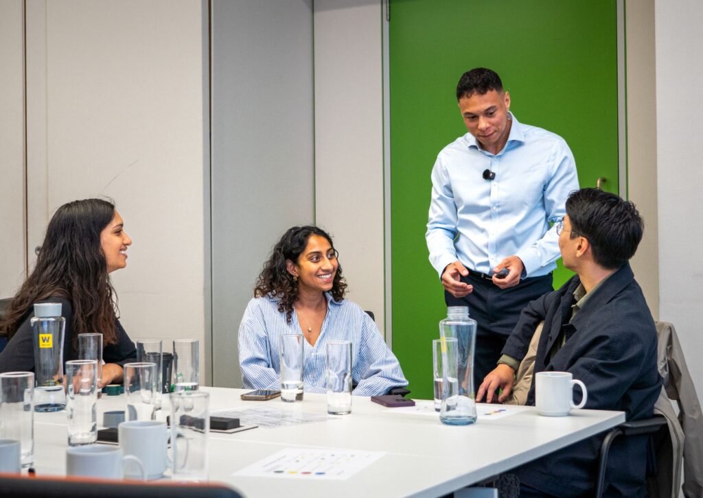 employees-smiling-while-Tyler-talks-to-them-in-a-team-workshop