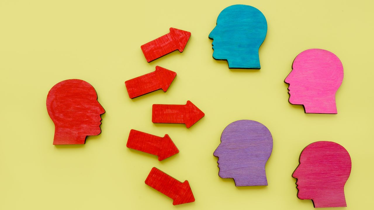Colourful face silhouettes and arrows representing influence at work.