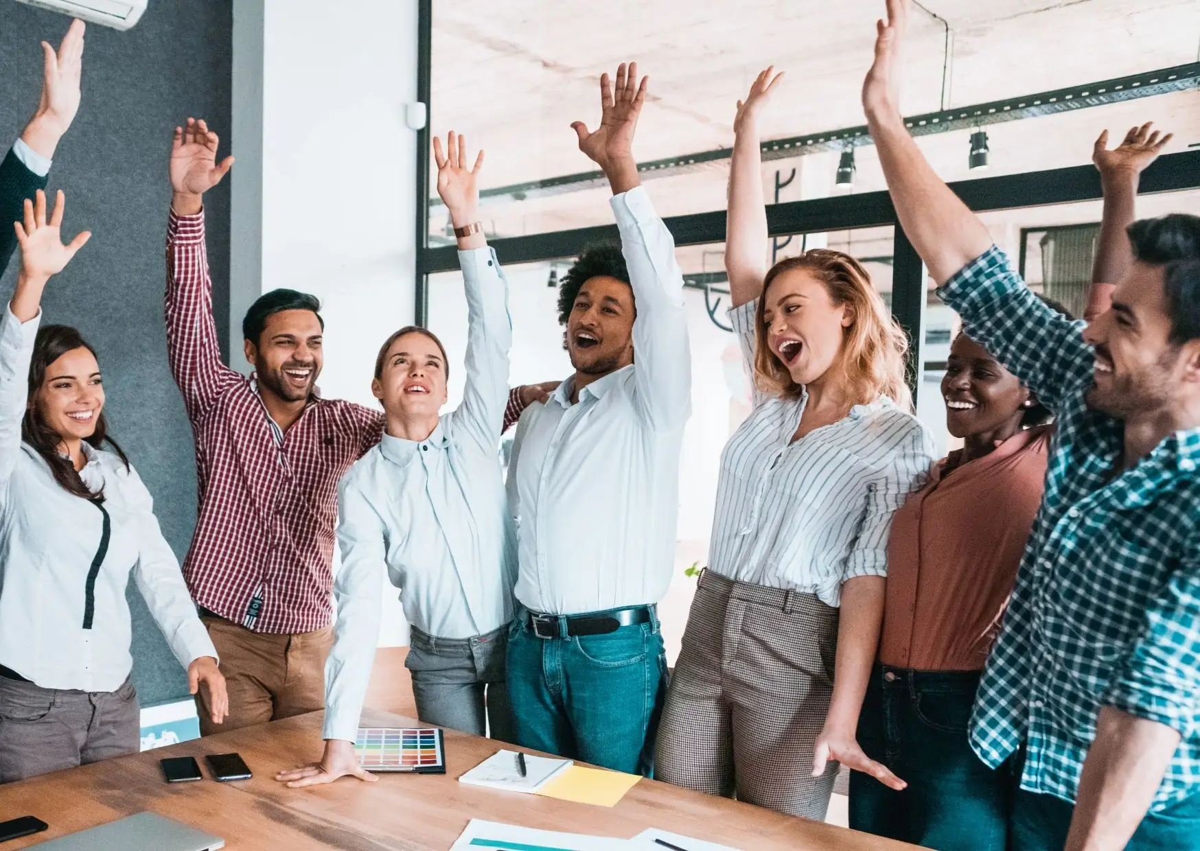 Motivated team celebrating together—energised and aligned after a workplace motivation webinar.