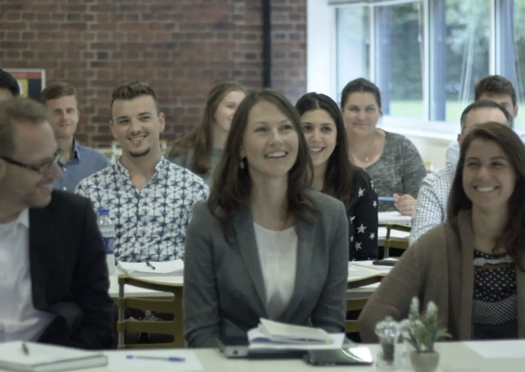 A diverse group of happy employees participating in a wellbeing workshop.