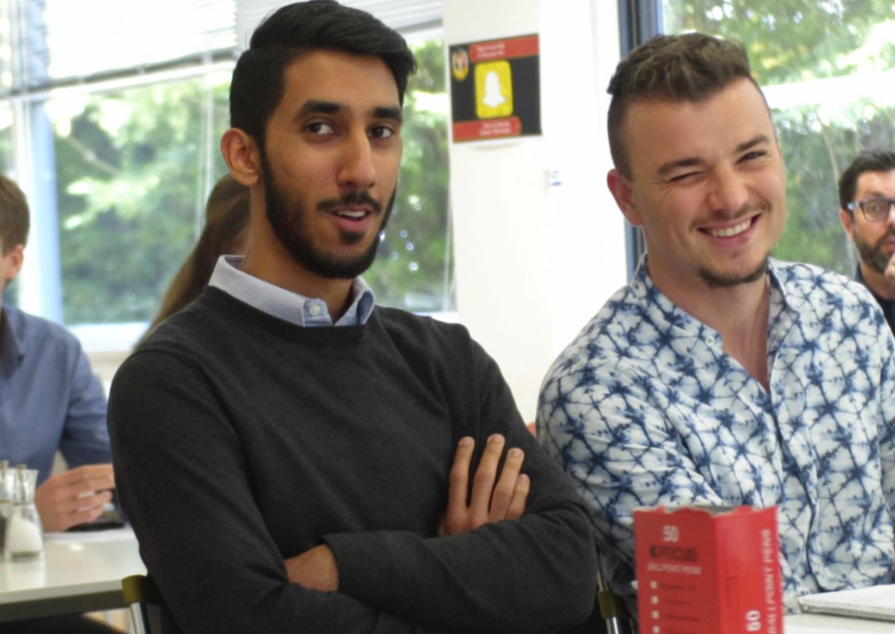 Group of men smiling at the camera during a team workshop.