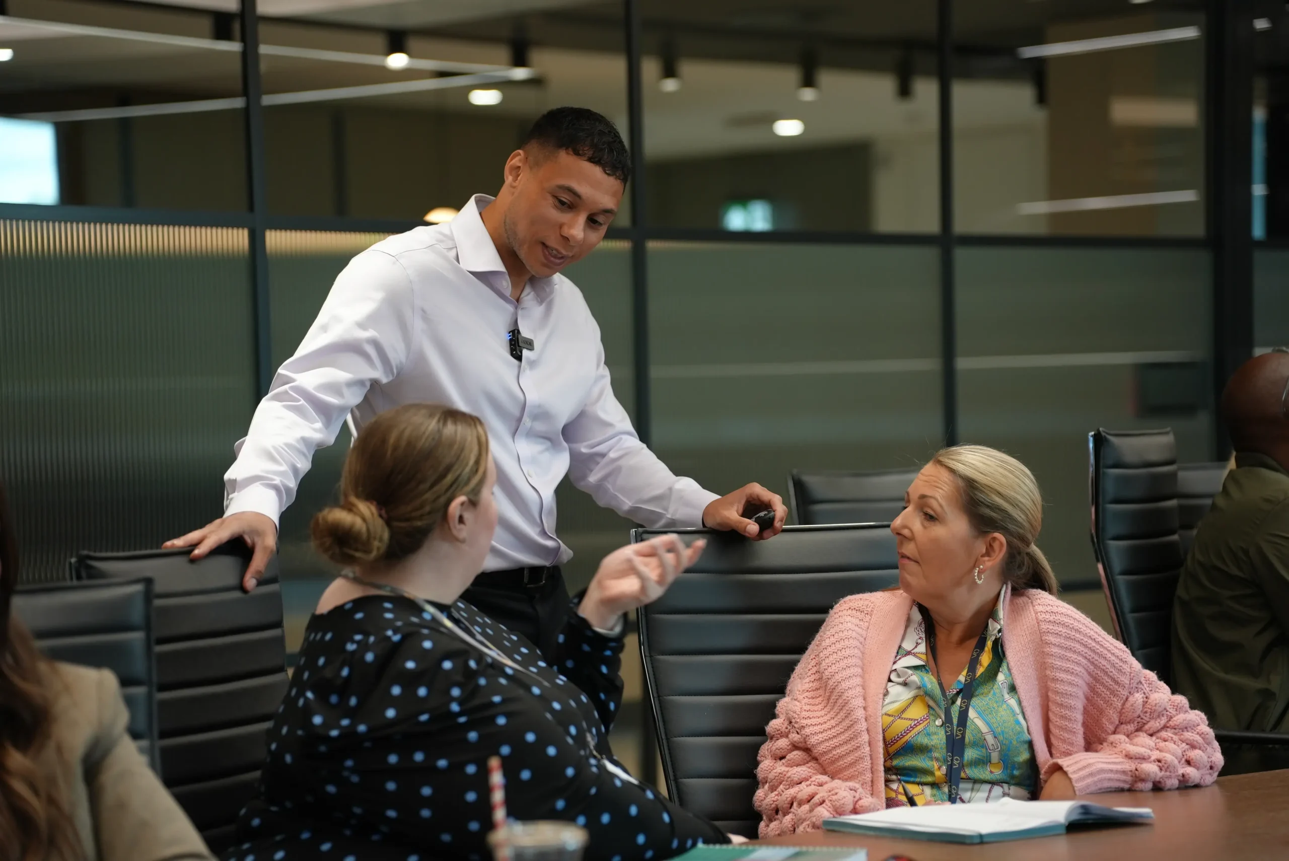 Workshop facilitator talking to employees during a team session in the UK.