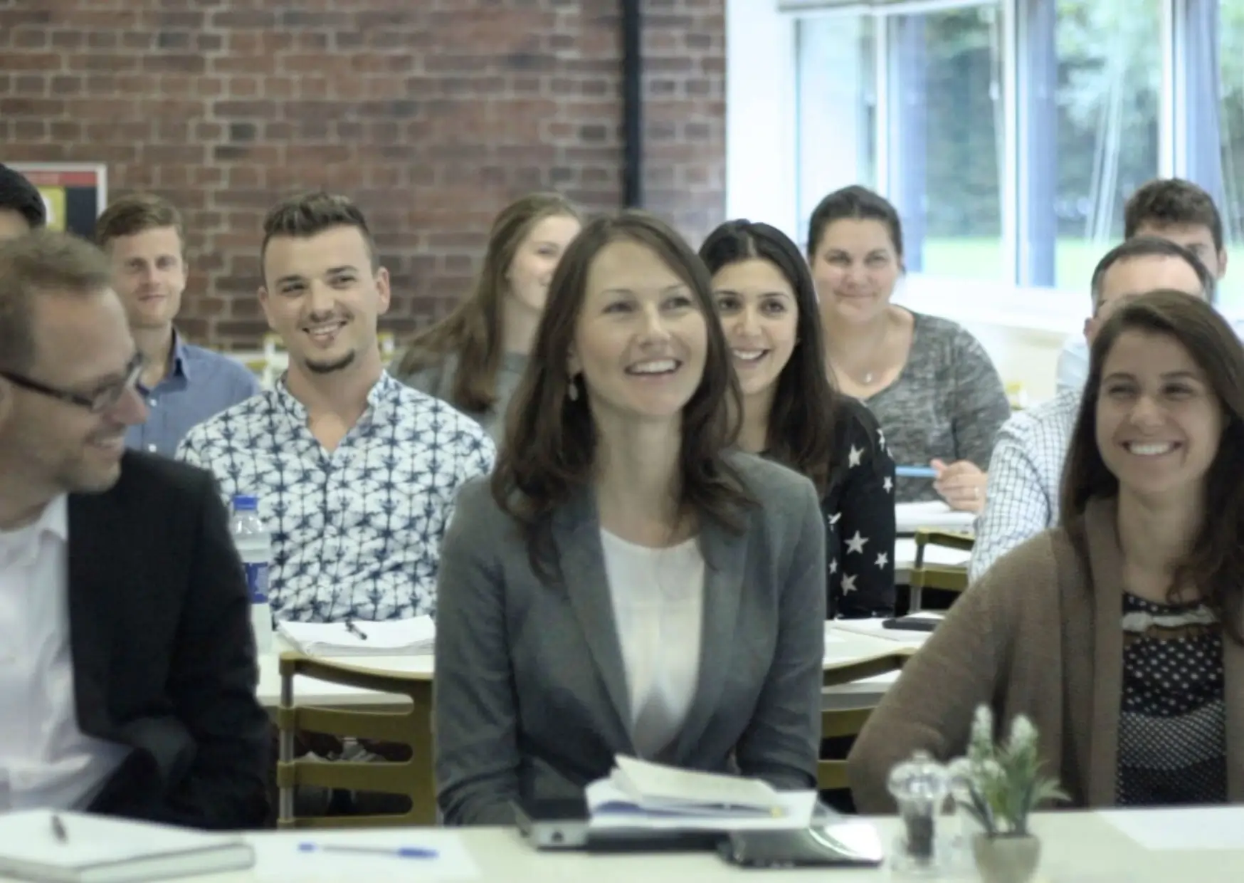 Employees smiling and engaged during a workplace wellbeing workshop.